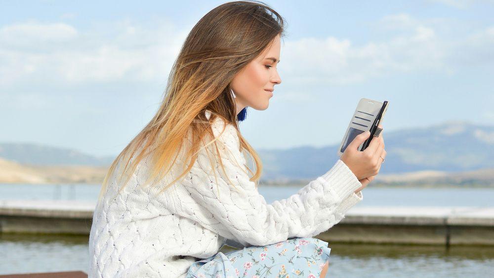 Una mujer revisa su teléfono móvil mientras está de vacaciones.