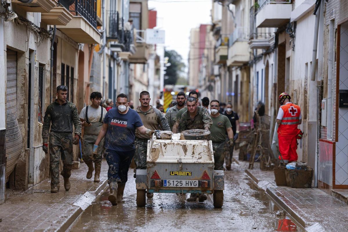 Soldados y voluntario trabajan en la limpieza de las calles de Paiporta, este martes.