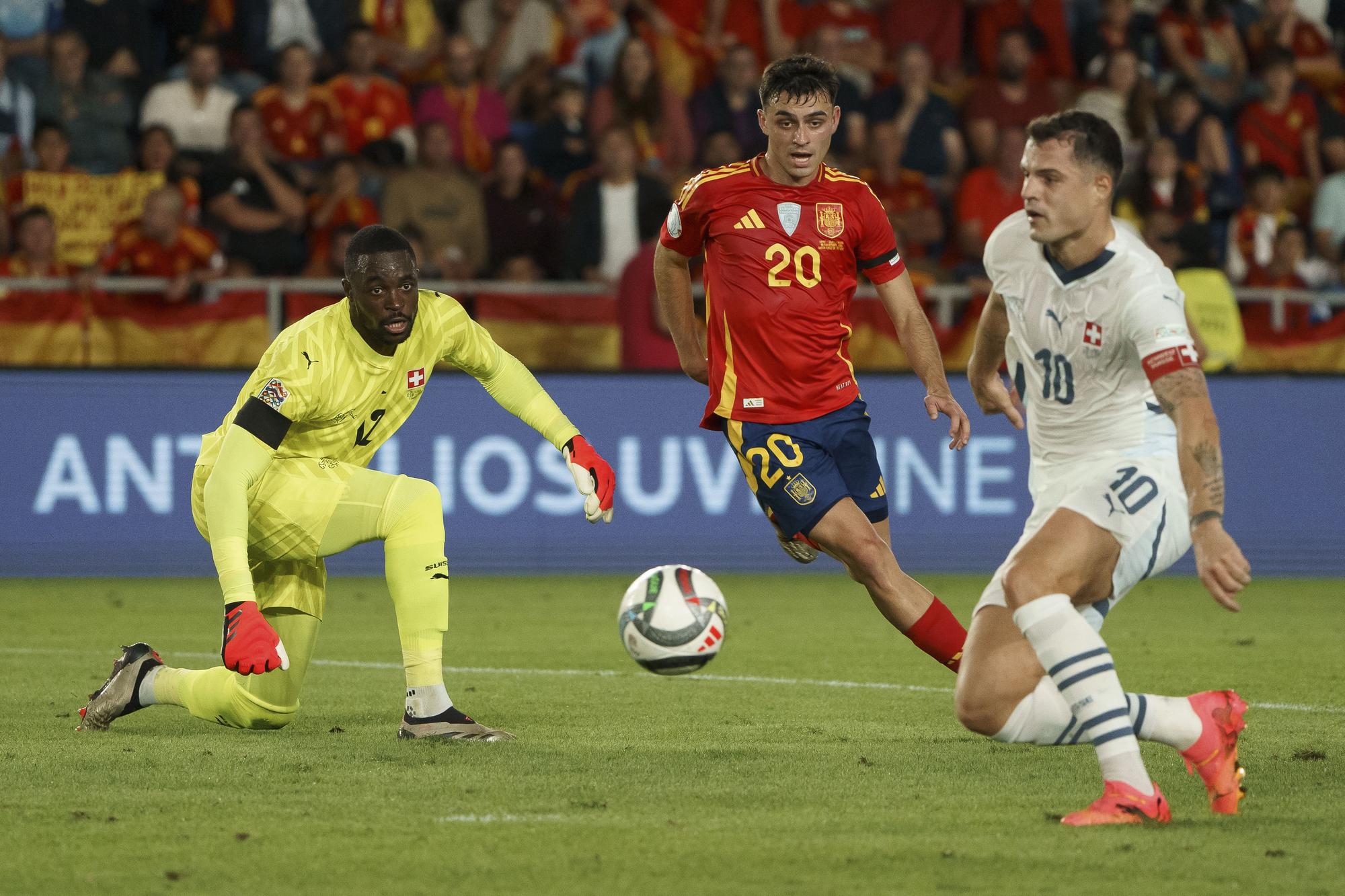 El centrocampista de la selección española Pedri (c) ante el centrocampista de la selección suiza, Granit Xhaka (d) y el portero de Suiza, Mvogo (i) durante el partido de la sexta jornada de la UEFA Nations League, entre España y Suiza , disputado en el estadio Heliodoro Rodríguez López de Santa Cruz de Tenerife. EFE/Ramón de la Rocha