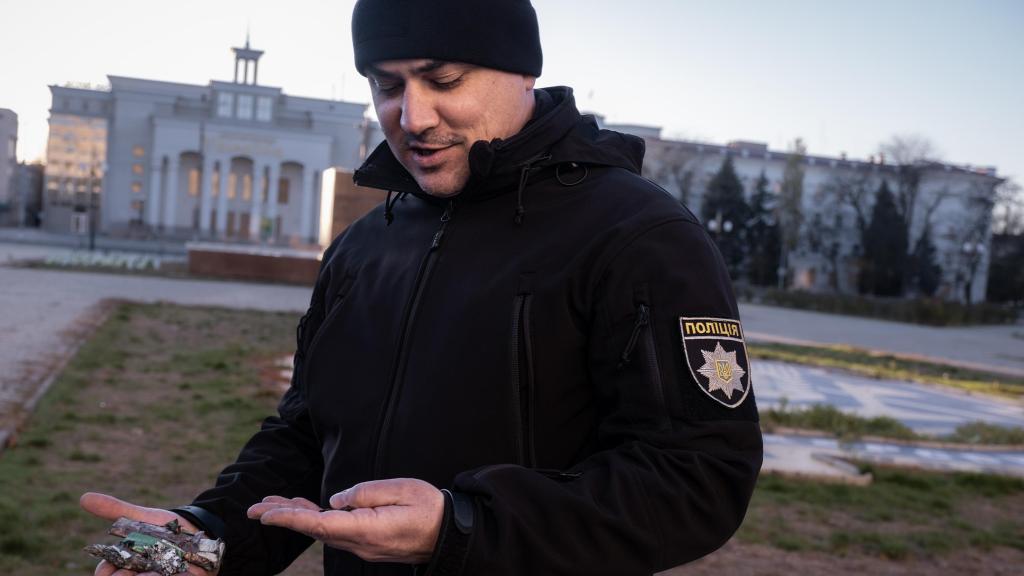 El coronel Andriy Kovani, portavoz de la policía de Kherson, muestra fragmentos de recientes ataques con artillería y drones en el centro de la ciudad.