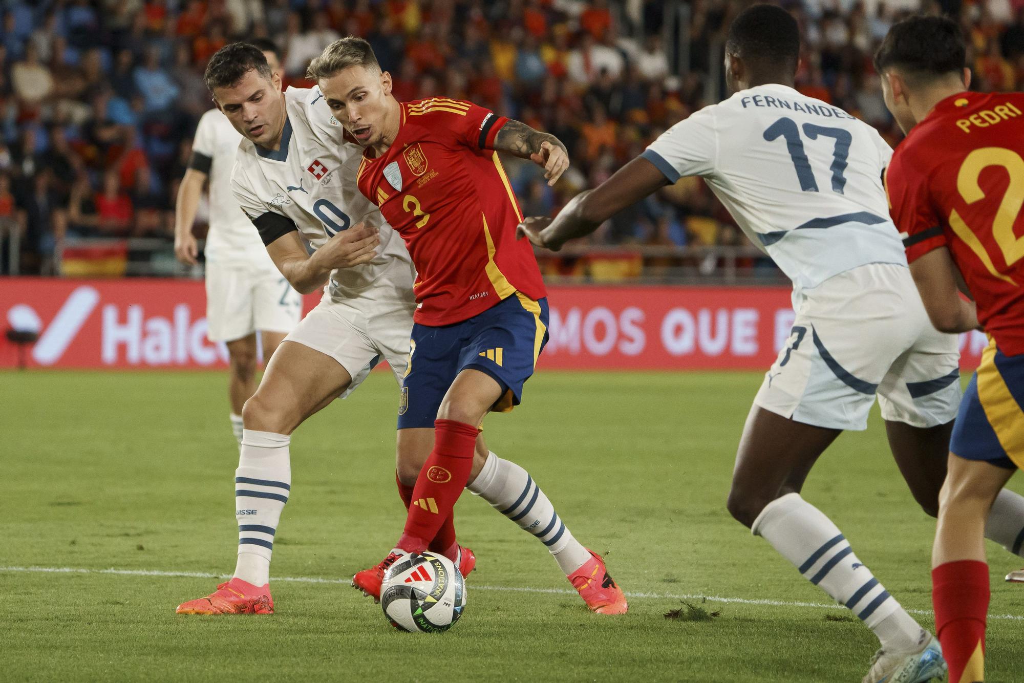 SANTA CRUZ DE TENERIFE, 18/11/2024.- El defensor de la selección española, Alejandro Grimaldo (2i), protege el balón contra el centrocampista de la selección suiza, Granit Xhaka, durante el partido de la sexta jornada de la Liga UEFA Naciones jugó este lunes en el estadio Heliodoro Rodríguez López de Santa Cruz de Tenerife. EFE/Ramón de la Rocha