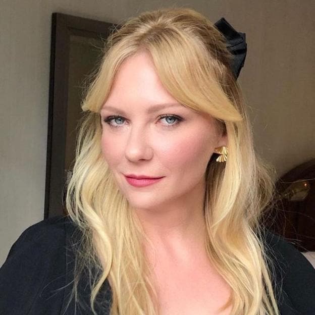 Kristen Dunst con un corte de pelo bardot con flequillo de cortina para una cara redonda