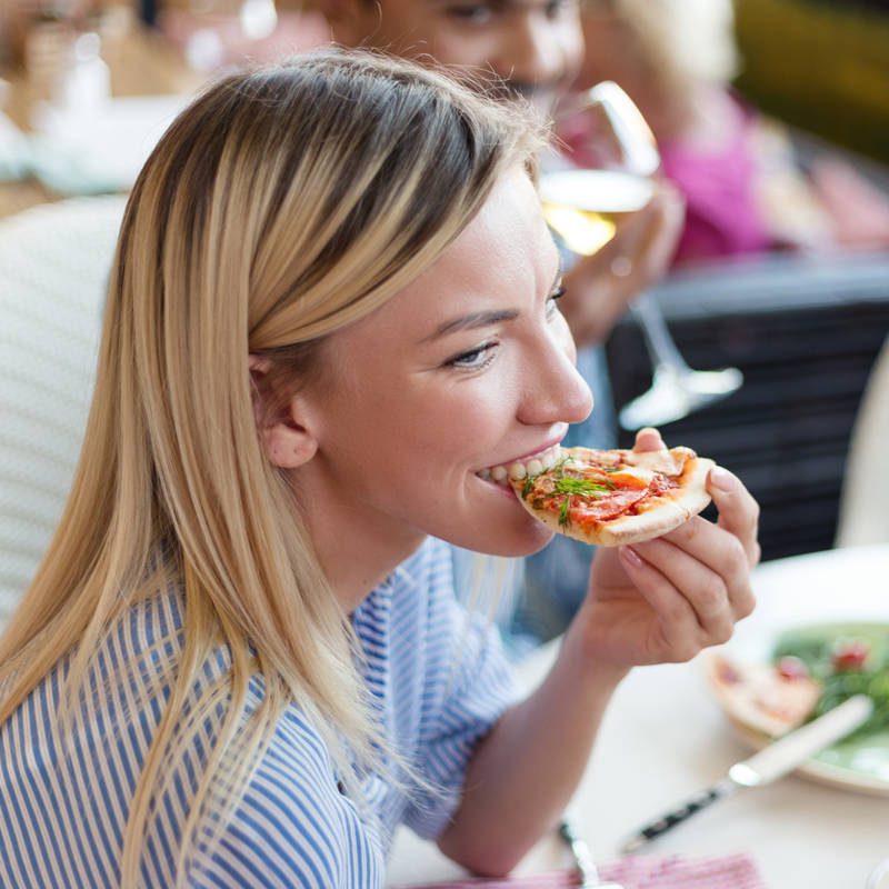 mujer comiendo pizza