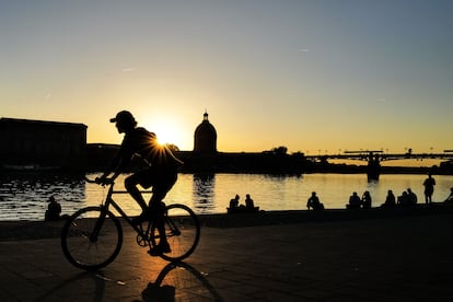 Un ciclista pasa por la orilla del río Garona, una vía fluvial que atraviesa la ciudad de Toulouse.