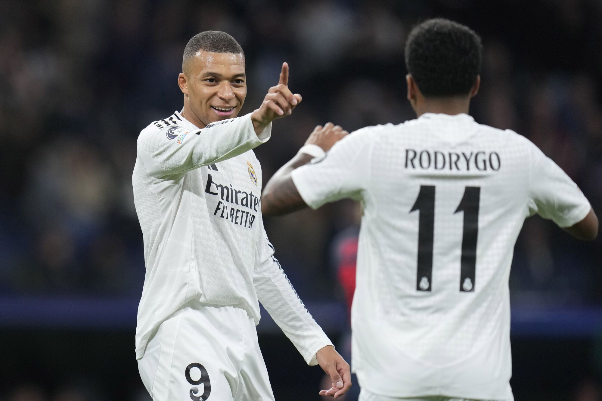 Rodrygo, derecha, del Real Madrid, celebra con su compañero Kylian Mbappé después de anotar el segundo gol de su equipo durante el partido de fútbol de la fase inaugural de la Liga de Campeones entre el Real Madrid y el FC Salzburg en el estadio Santiago Bernabeu de Madrid, el miércoles 22 de enero de 2025. (AP Foto/Manu Fernández)