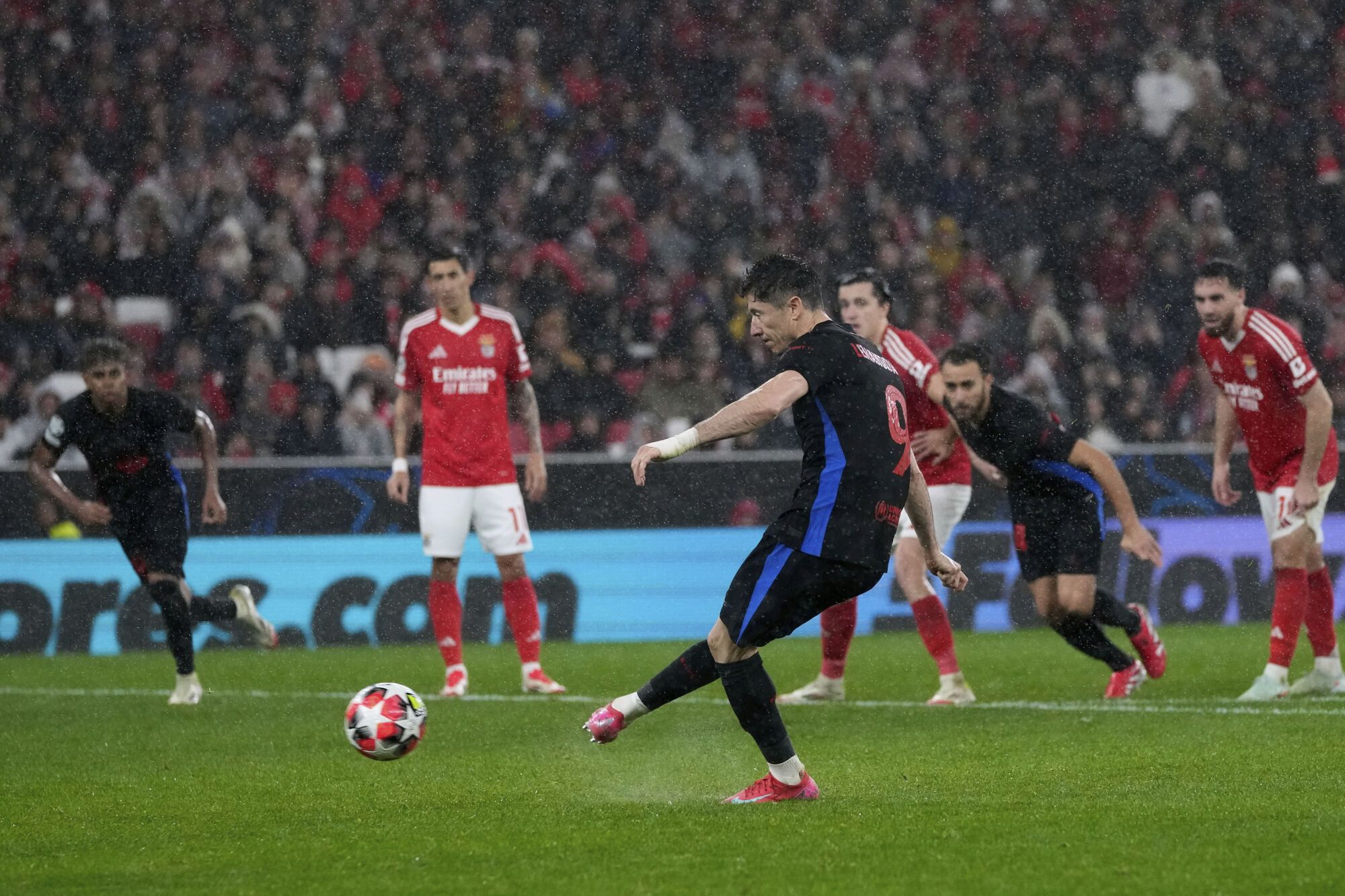 Barcelona's Robert Lewandowski scores his side's third goal from a penalty shot, during a Champions League opening phase soccer match between SL Benfica and FC Barcelona at the Luz stadium in Lisbon, Tuesday, Jan. 21, 2025. (AP Photo/Armando Franca)