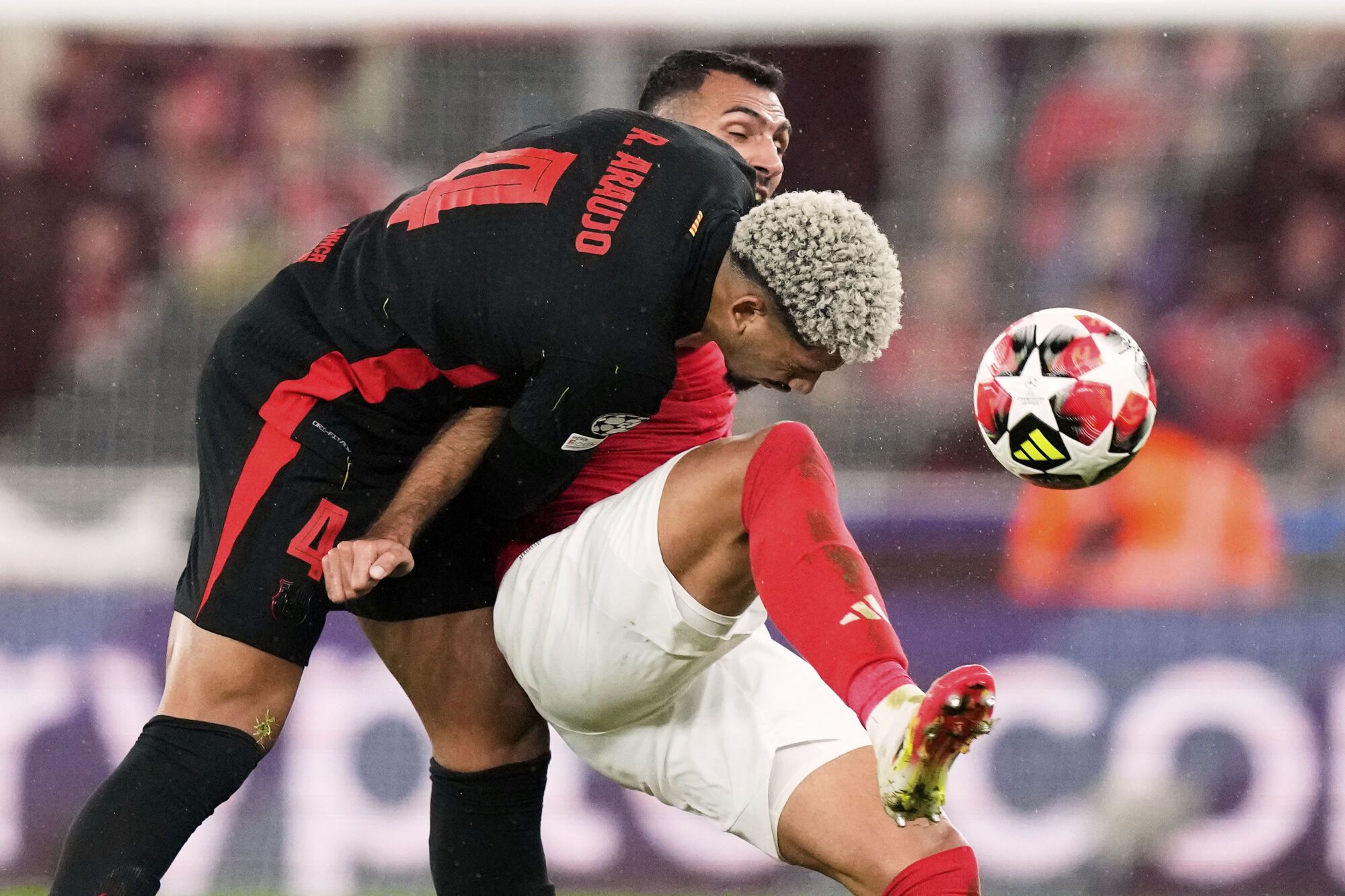 Barcelona's Ronald Araujo fights for the ball against Benfica's Vangelis Pavlidis during a Champions League opening phase soccer match between SL Benfica and FC Barcelona at the Luz stadium in Lisbon, Tuesday, Jan. 21, 2025. (AP Photo/Armando Franca)