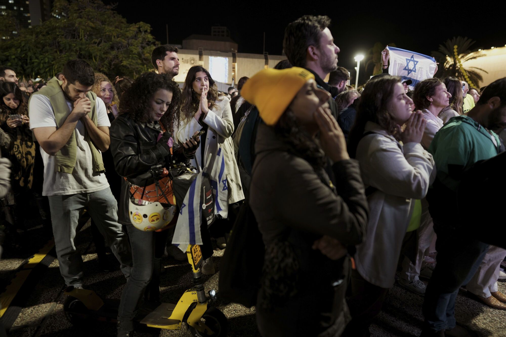 Relatives and friends of people killed and abducted by Hamas and taken into Gaza, react to the news of the hostages' release, as they gather in Tel Aviv, Israel on Sunday, Jan. 19, 2025. (AP Photo/Oded Balilty)