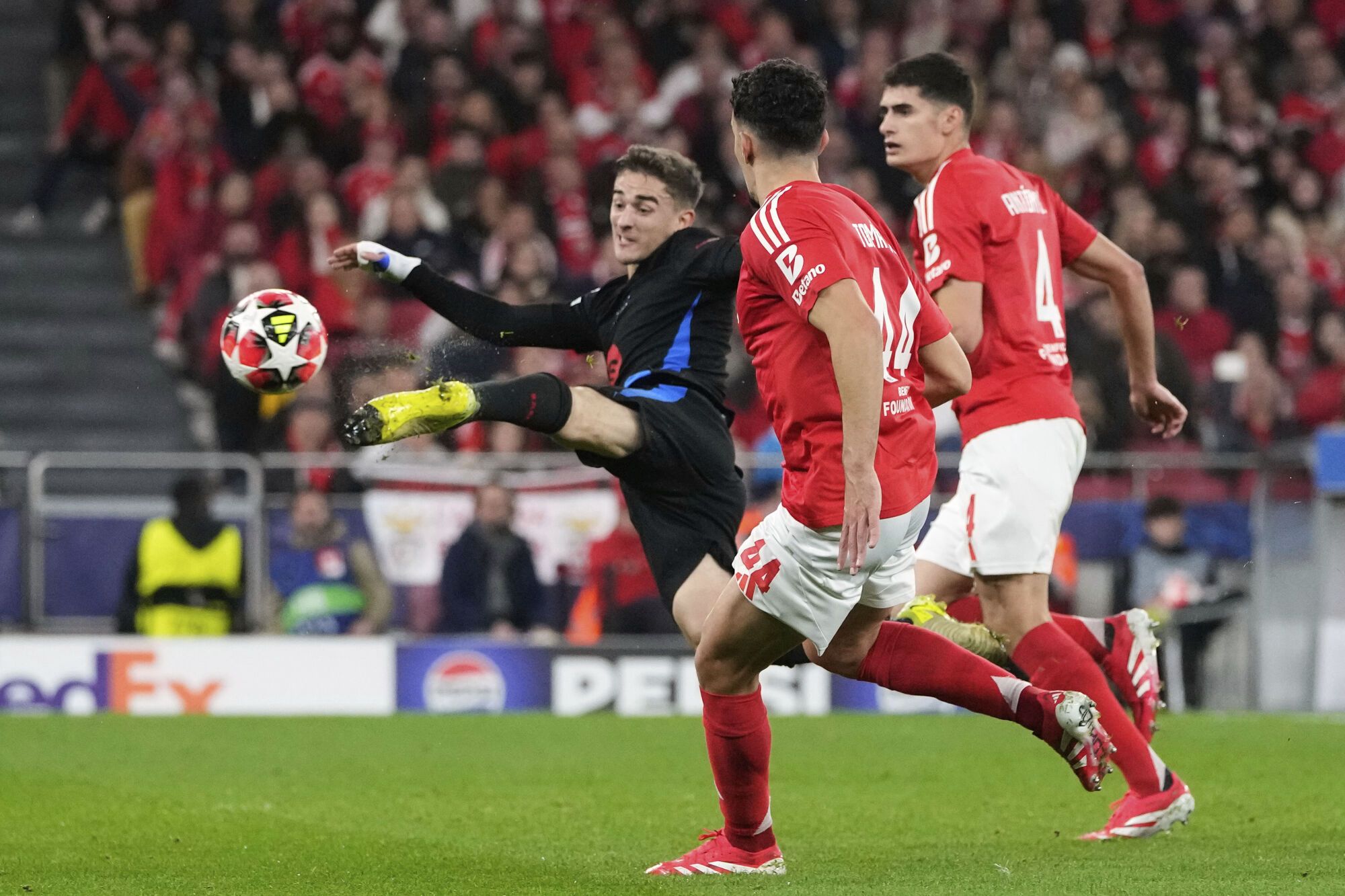 Barcelona's Gavi tries to shot next to Benfica's Tomas Araujo and Antonio Silva during a Champions League opening phase soccer match between SL Benfica and FC Barcelona at the Luz stadium in Lisbon, Tuesday, Jan. 21, 2025. (AP Photo/Armando Franca). EDITORIAL USE ONLY / ONLY ITALY AND SPAIN