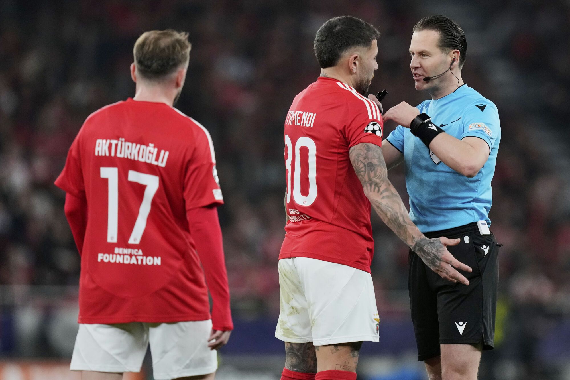 Referee Danny Makkelie speaks with Benfica's Nicolas Otamendi during a Champions League opening phase soccer match between SL Benfica and FC Barcelona at the Luz stadium in Lisbon, Tuesday, Jan. 21, 2025. (AP Photo/Armando Franca)