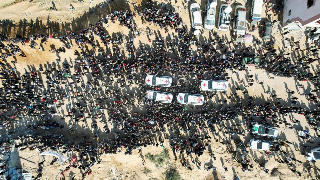 Una vista de un dron muestra una multitud que rodea vehículos de la Cruz Roja durante la entrega de dos rehenes en Jan Yunis.