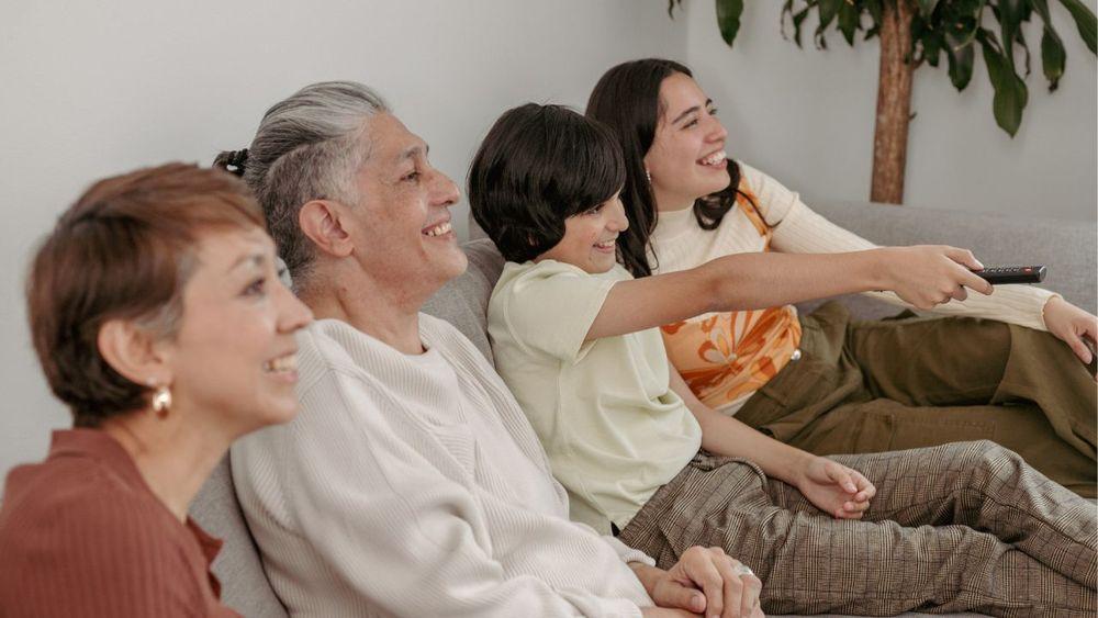 Familia sentada en el sofá viendo la televisión