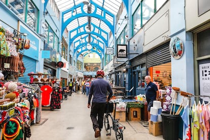 Gente en tiendas, cafés y puestos en el popular mercado de Brixton Village, en el barrio de South London (Inglaterra).