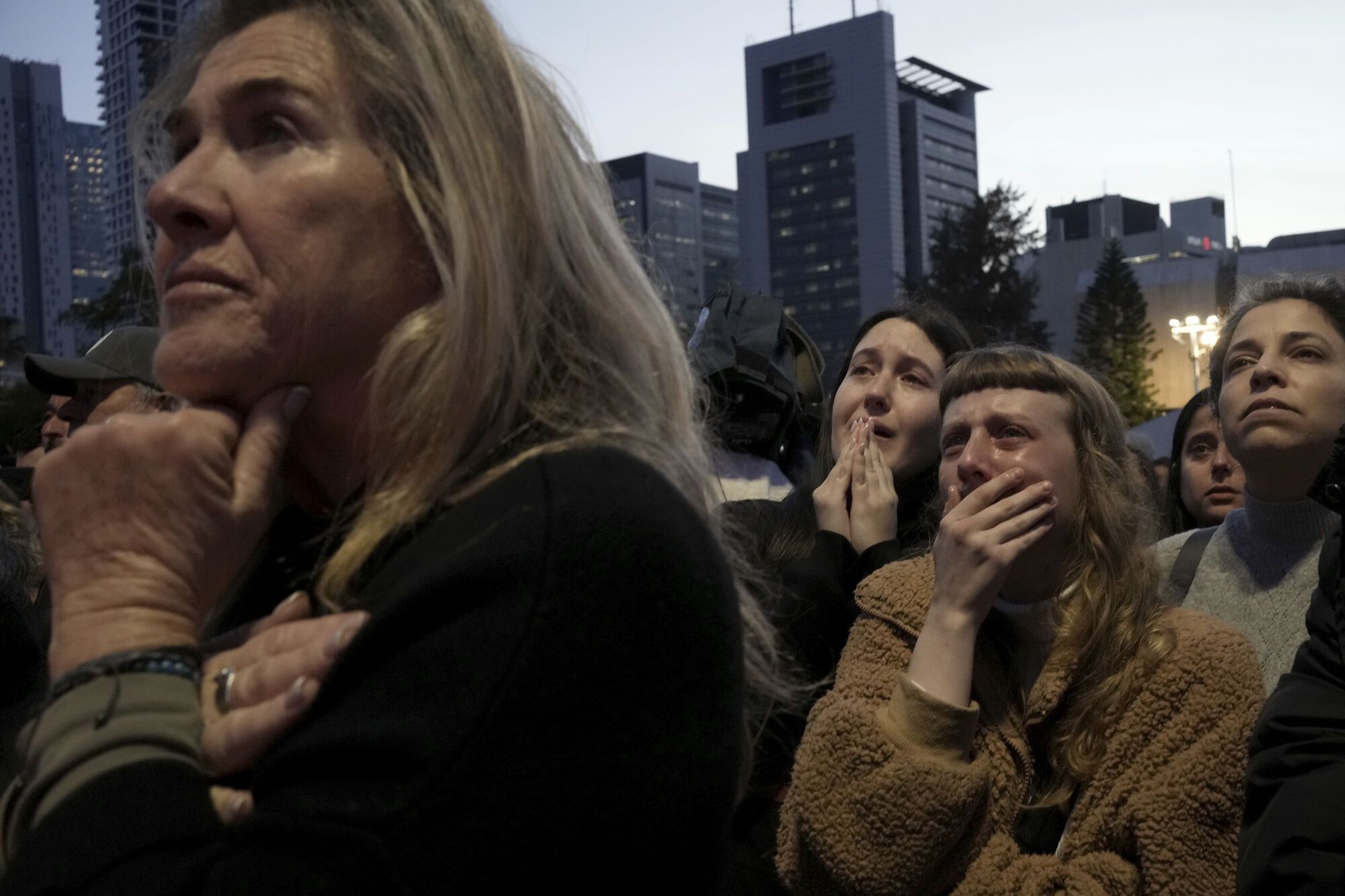 Relatives and friends of people killed and abducted by Hamas and taken into Gaza, react to the news of the hostages' release, as they gather in Tel Aviv, Israel on Sunday, Jan. 19, 2025. (AP Photo/Maya Alleruzzo)