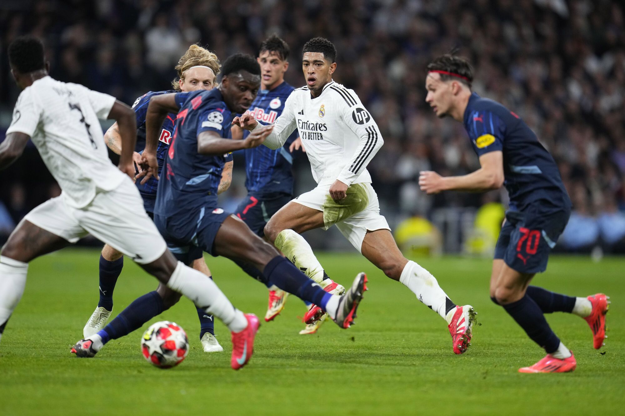 Jude Bellingham del Real Madrid, centro, en acción durante el partido de fútbol de la fase inaugural de la Liga de Campeones entre el Real Madrid y el FC Salzburg en el estadio Santiago Bernabéu de Madrid, el miércoles 22 de enero de 2025. (Foto AP/Manu Fernández)