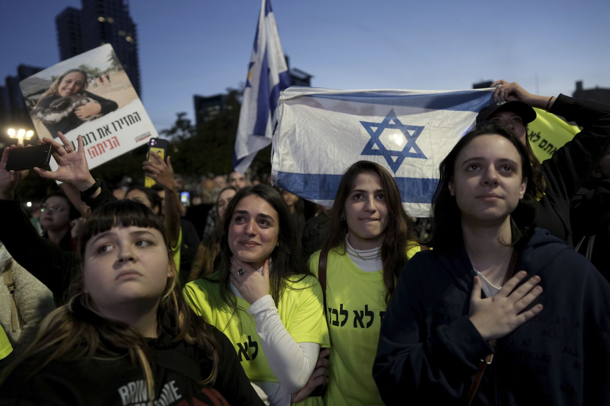 Relatives and friends of people killed and abducted by Hamas and taken into Gaza, react to the news of the hostages' release, as they gather in Tel Aviv, Israel on Sunday, Jan. 19, 2025. (AP Photo/Oded Balilty). EDITORIAL USE ONLY / ONLY ITALY AND SPAIN