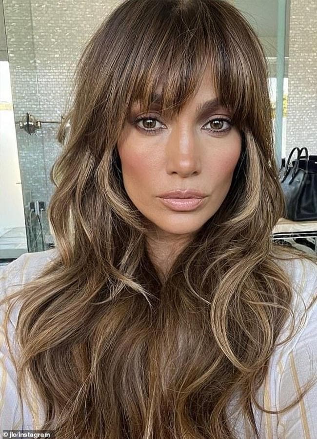 Jennifer López con flequillo de cortina en cabello largo y ondulado/@jlo