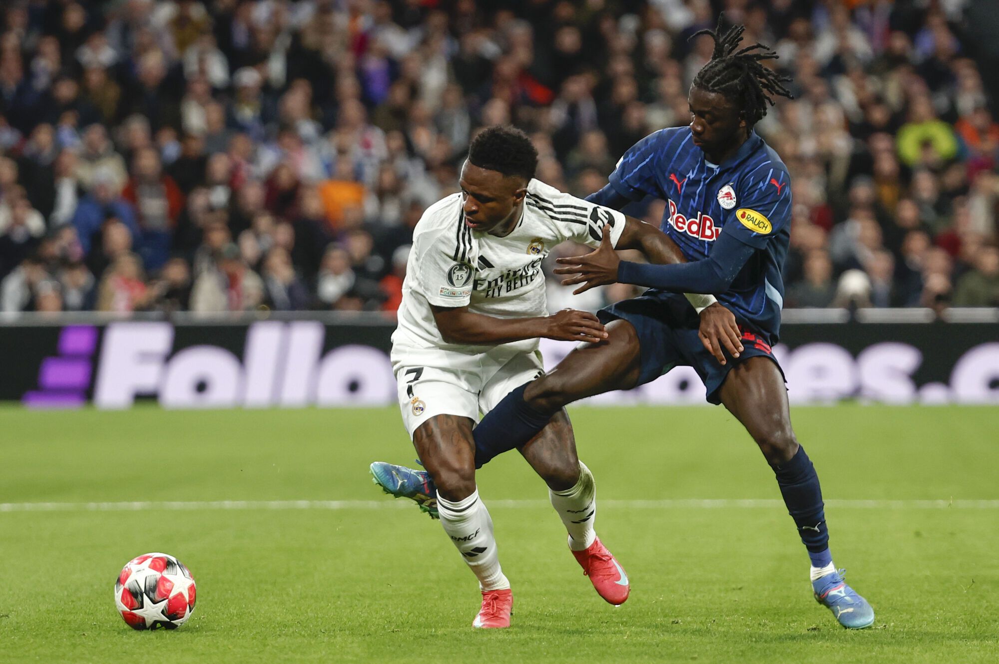 MADRID, 22/01/2025.- El delantero brasileño del Real Madrid Vinicius Junior (i) lucha por un balón con el centrocampista Moussa Yeo, de Salzburgo, durante el partido de fútbol de la Liga de Campeones entre el Real Madrid y el FC Salzburg de este año. Miércoles en el estadio Santiago Bernabéu. EFE/Sergio Pérez