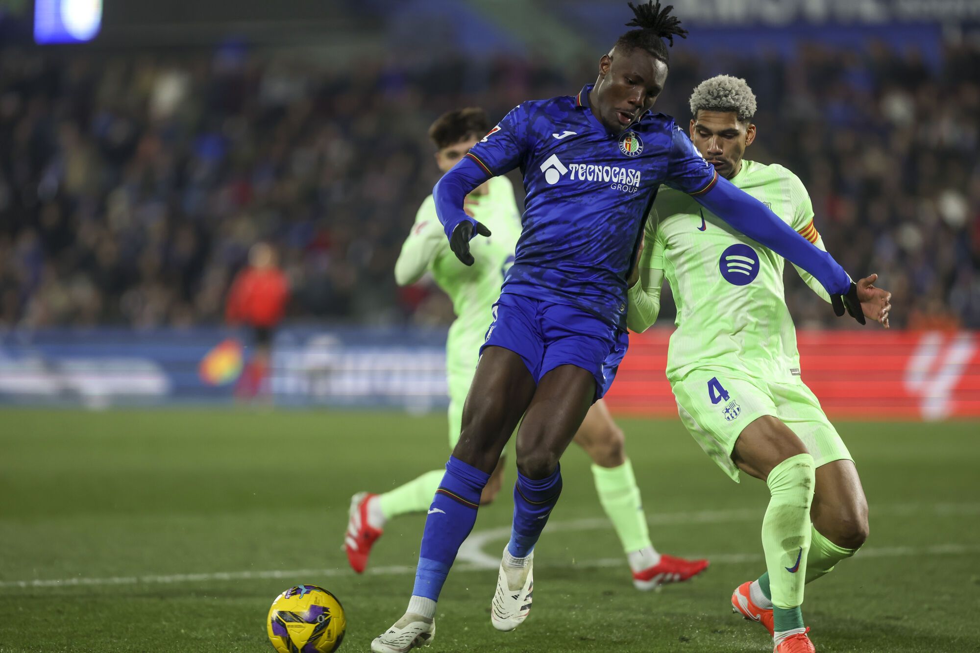 GETAFE (MADRID), 18/01/2025.- El centrocampista nigeriano del Getafe, Chrisantus Uche (i), protege el balón ante el defensa uruguayo del FC Barcelona, ​​Ronald Araujo, durante el partido correspondiente a la jornada 20 de Laliga EA Sports que disputan Getafe y FC Barcelona Juegan hoy sábado en el Coliseum de Getafe. EFE/Kiko Huesca.