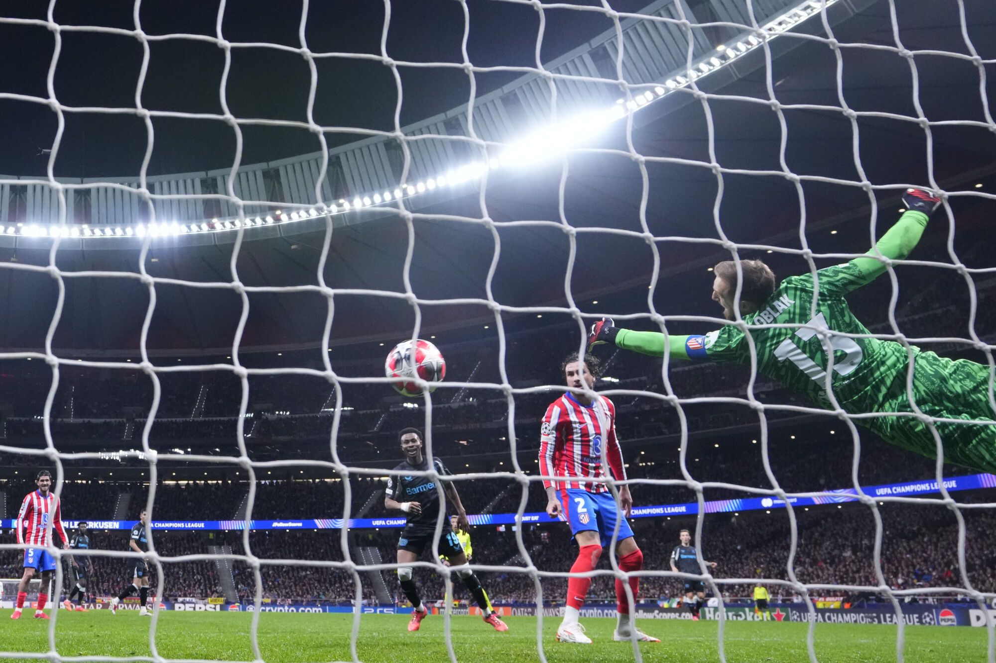 El portero del Atlético de Madrid, Jan Oblak, intenta detener un balón durante un partido de fútbol de la fase inaugural de la Liga de Campeones contra el Bayer 04 Leverkusen en el estadio Riyadh Air Metropolitano en Madrid, España, el martes 21 de enero de 2025. (Foto AP/Manu Fernández)