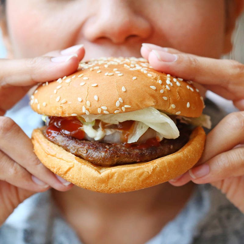 Mujer comiendo una hamburguesa