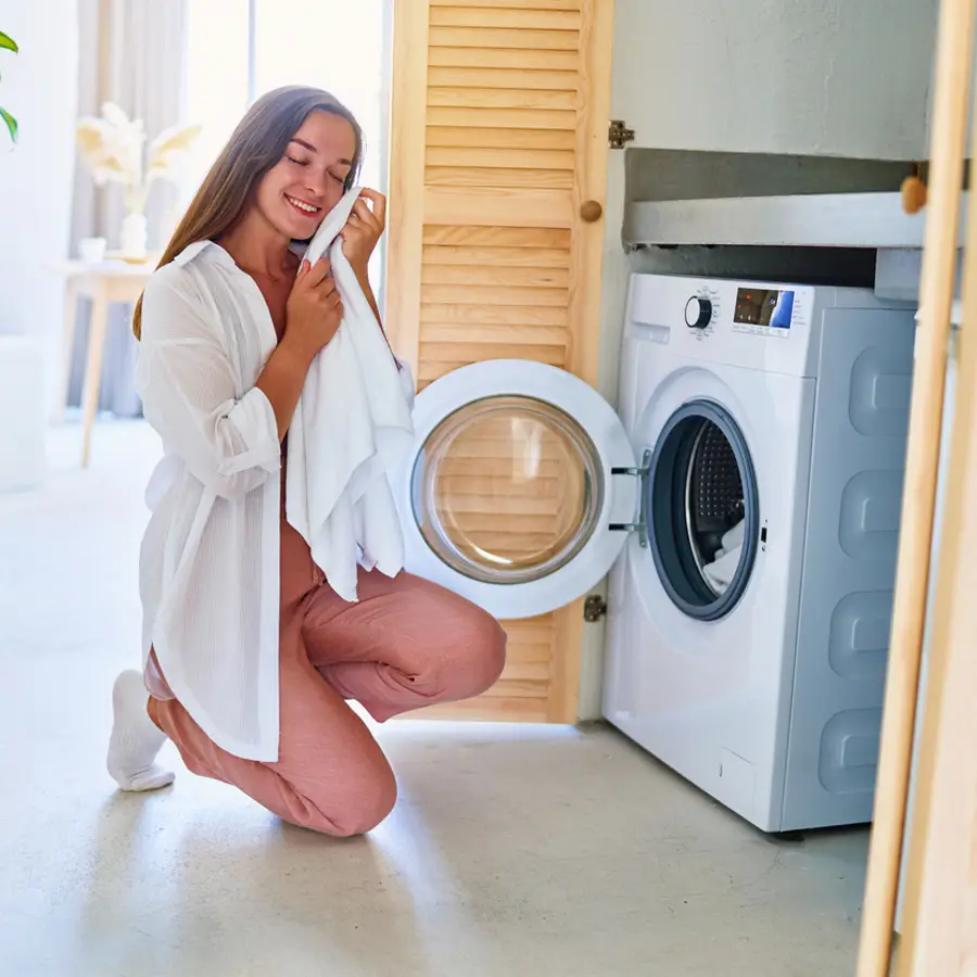 Mujer sacando ropa de la lavadora