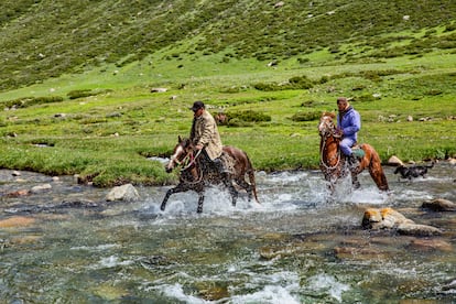 Dos corredores cruzan el río Tup, en Kyrguistán.