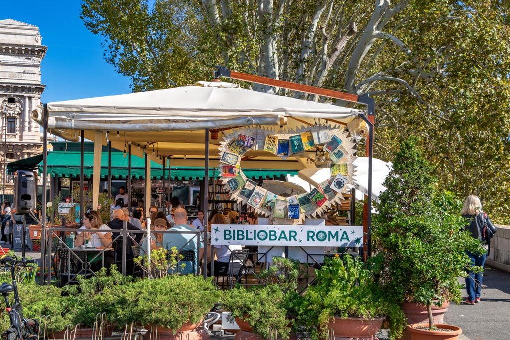 Gente disfrutando comiendo y bebiendo en El Bibliobar, en Roma, Italia