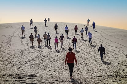 Varios turistas descargaron en la cima de Duna Blanche, una montaña de arena blanca donde el Sahara y el Atlántico se derriten.