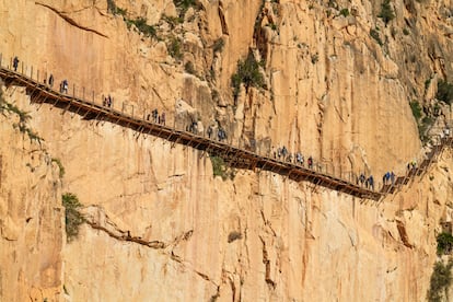 Excursionistas caminando sobre uno de los podios de El Caminito del Rey. 