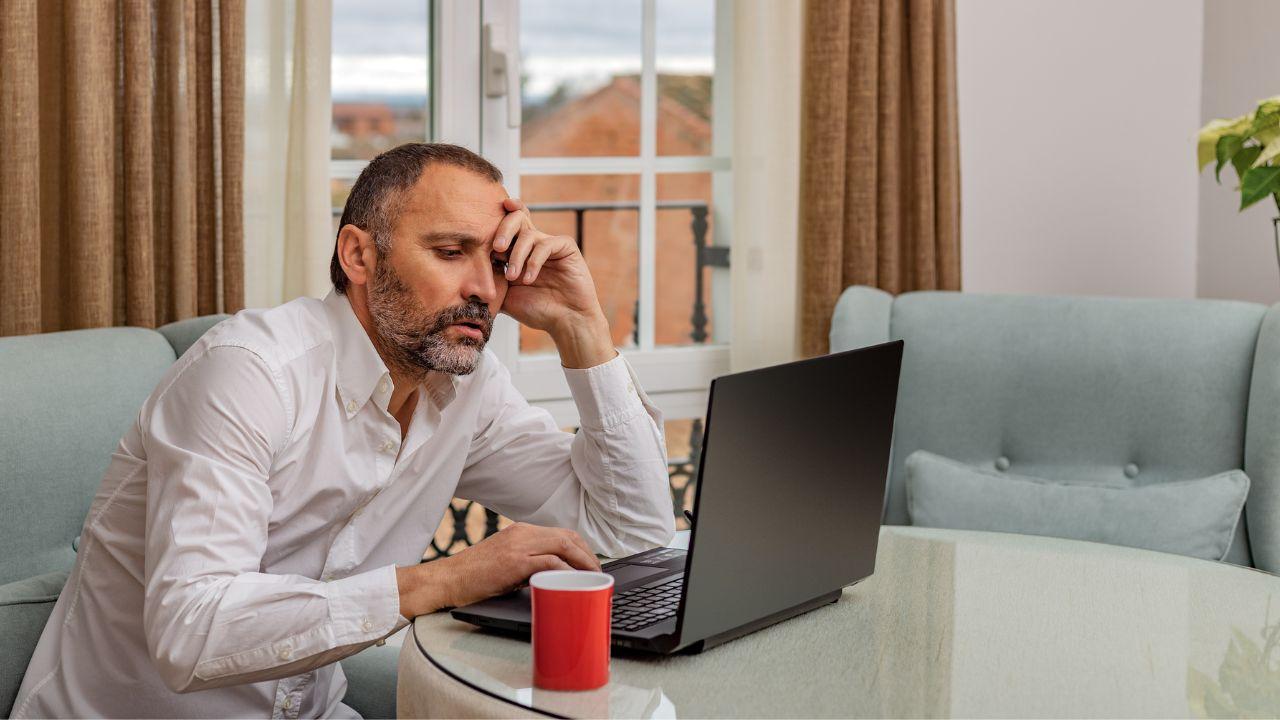 Un hombre cansado en la computadora portátil