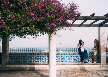 Dos mujeres de Mirador de Santa Lucía, para la ciudad de Lisboa y El Tajo.