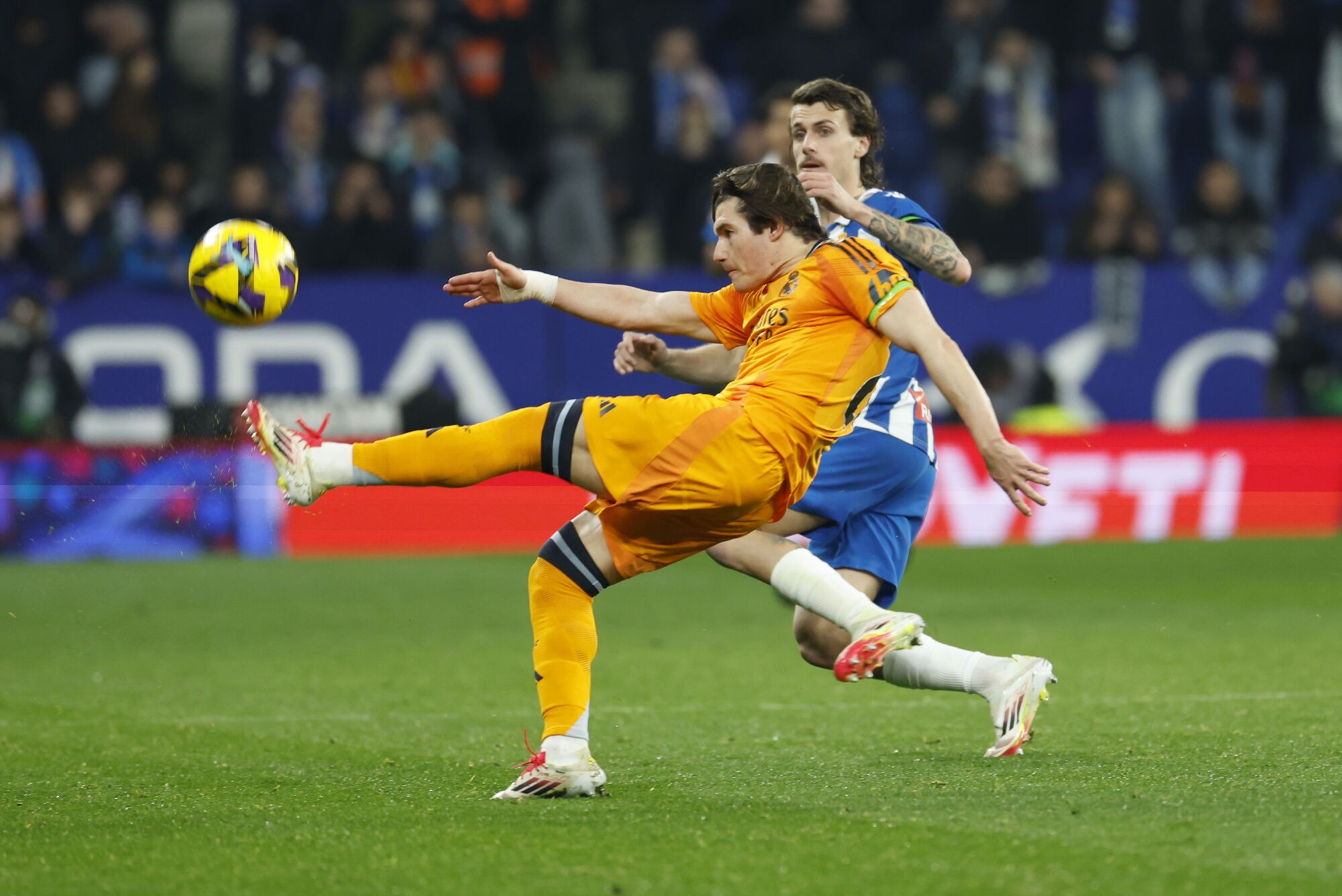 El defensor del Real Madrid, Fran García (L), despeja el balón contra el defensor de Espanyol, Carlos Romero durante Lalig