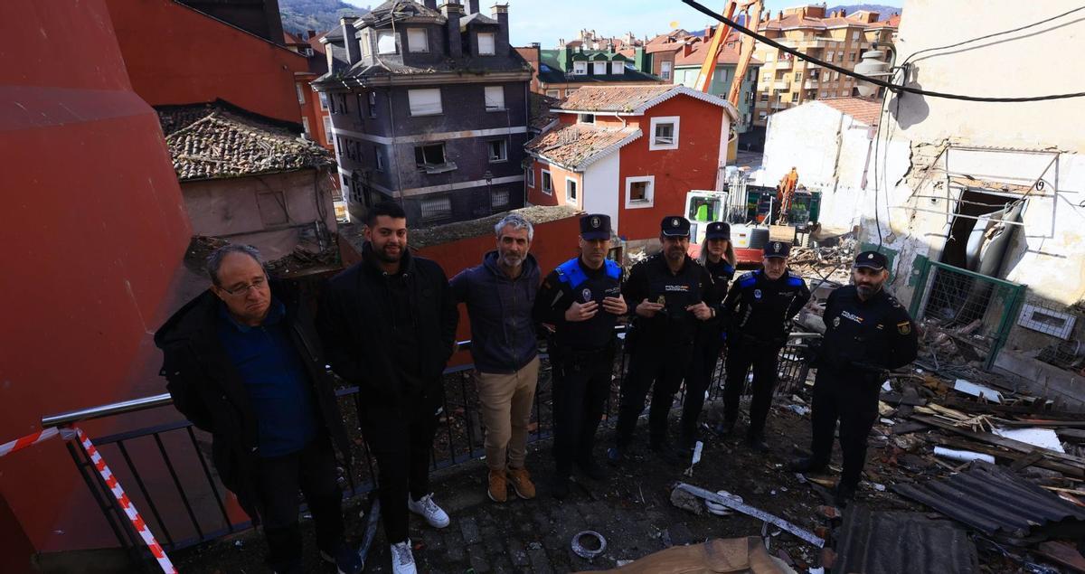 Por la izquierda, José Antonio Rubio, Brian Menéndez, José Manuel García Prado, Carlos Noval, Silvino Falcón, Ángela Sánchez y Damián Álvarez, ayer, justo a la barandilla que saltaron el pasado lunes para auxiliar a los vecinos que resultados sepultados en la explosión de gas que arrasó el corazón del barrio de La Villa. | DAVID CABO