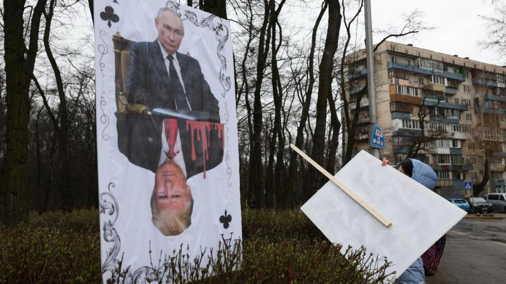 Cartel contra Trump y Putin en una protesta frente a la embajada de los Estados Unidos en Kiev mientras tenía conversaciones sobre un posible incendio.