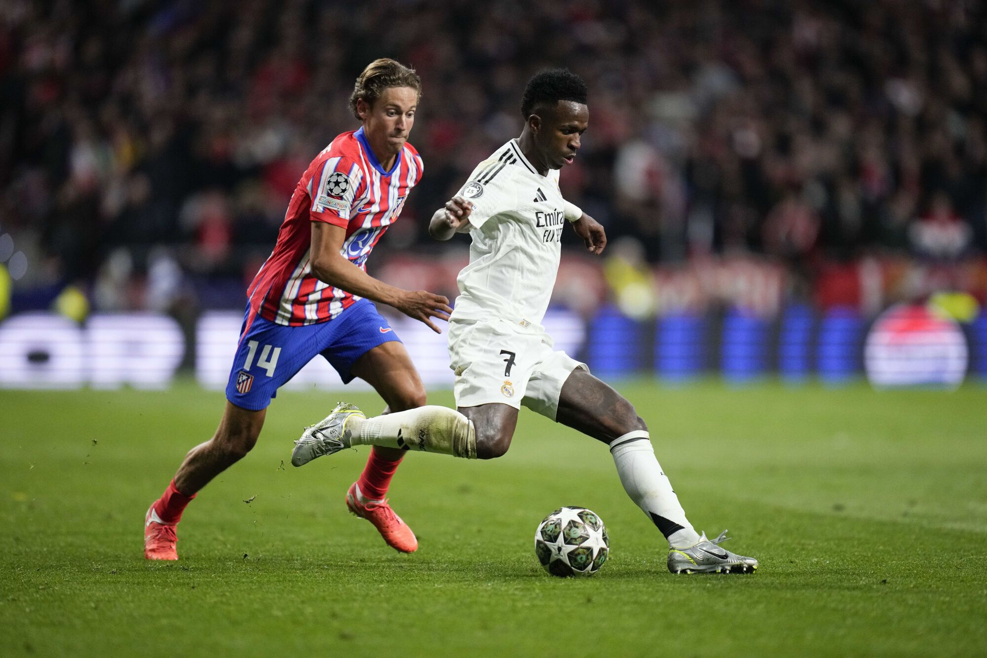 Real Madrid's Vinicius Junior in Action in Front of Athletic Madrid's Marcos Llorente During the Champions League Round of 16, Second Leg, Soccer Match Between Athletic Madrid and Real Madrid At The Metropolitan Stadium in Madrid, Spain, Wednesday, March 12, 2025. (Ap Photo/Bernat Armangue). Editorial Use Only/Only Italy And Spain