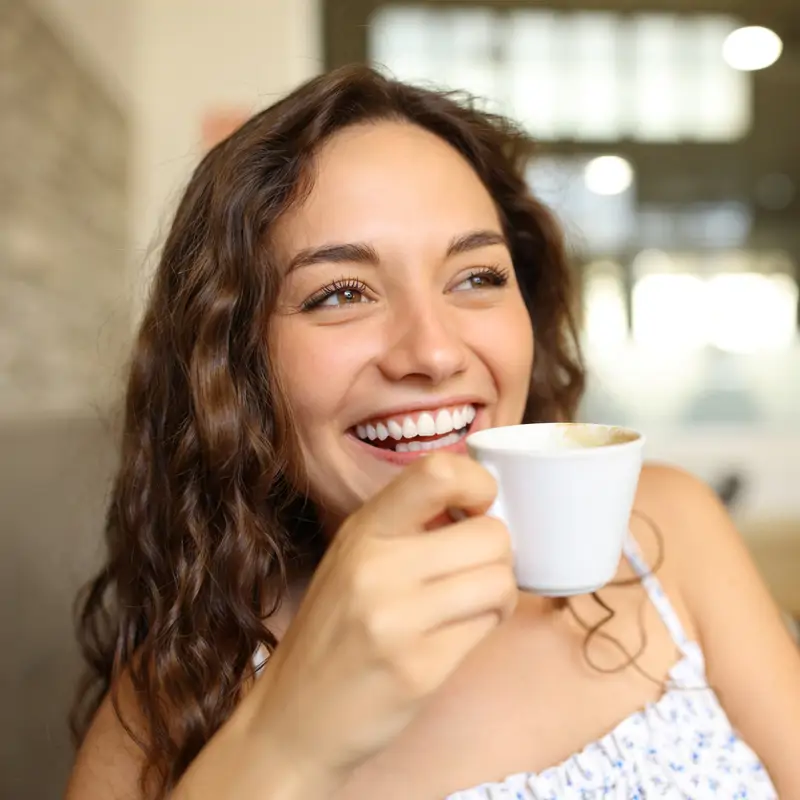 Mujer joven bebe café