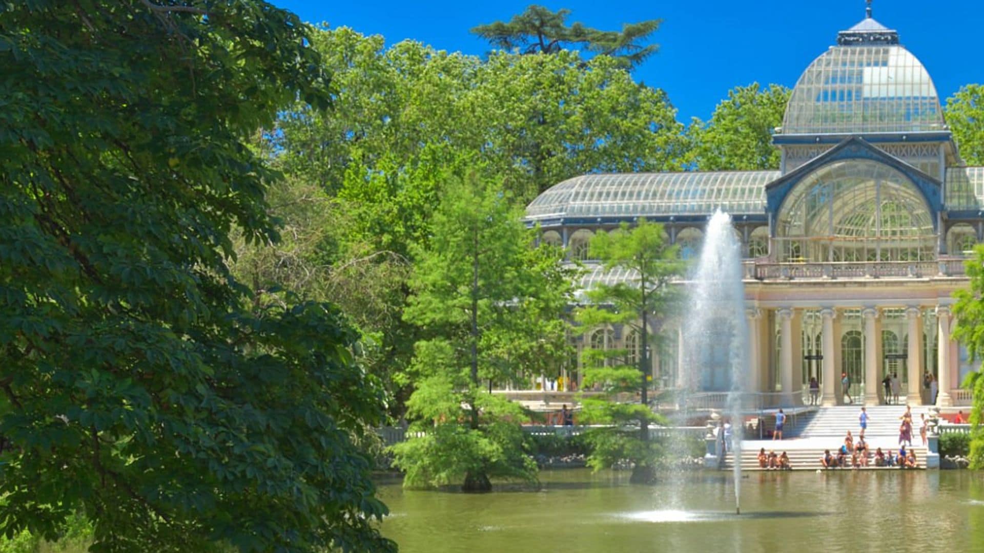 Lago, fuente, árboles y un cielo azul en los buenos jardines de jubilación de Madrid en verano