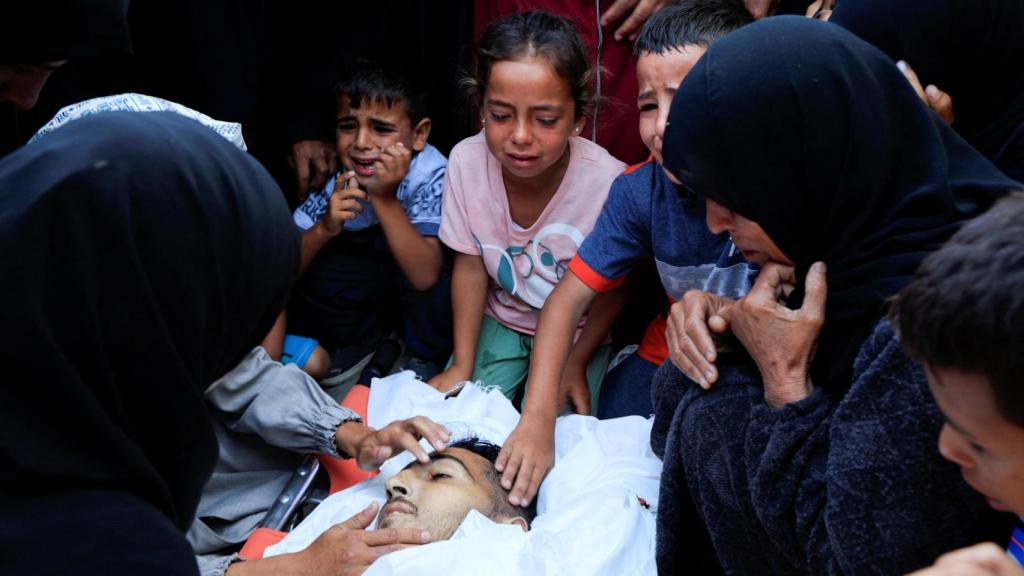 Algunos niños lloran a un pariente muerto debido a los bombardeos de Israel.