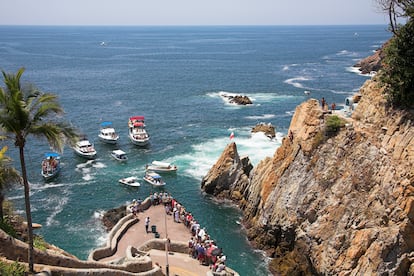 Curioso sobre los barcos o en el punto de vista, se acercan al acantilado del barranco para ver a los jinetes.