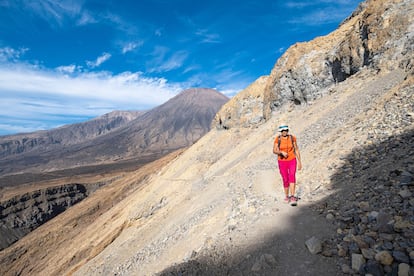 Un excursionista sigue uno de los senderos de la isla de Santo Antão, con el volcán el Topo da Coroa al fondo.