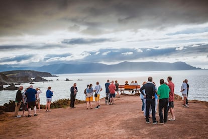 Varios turistas se concentran para fotografiarse en el llamado banco más bonito del mundo, en Loiba, Ortigueira.