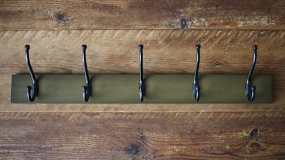 Una percha de pared con cinco ganchos de metal
