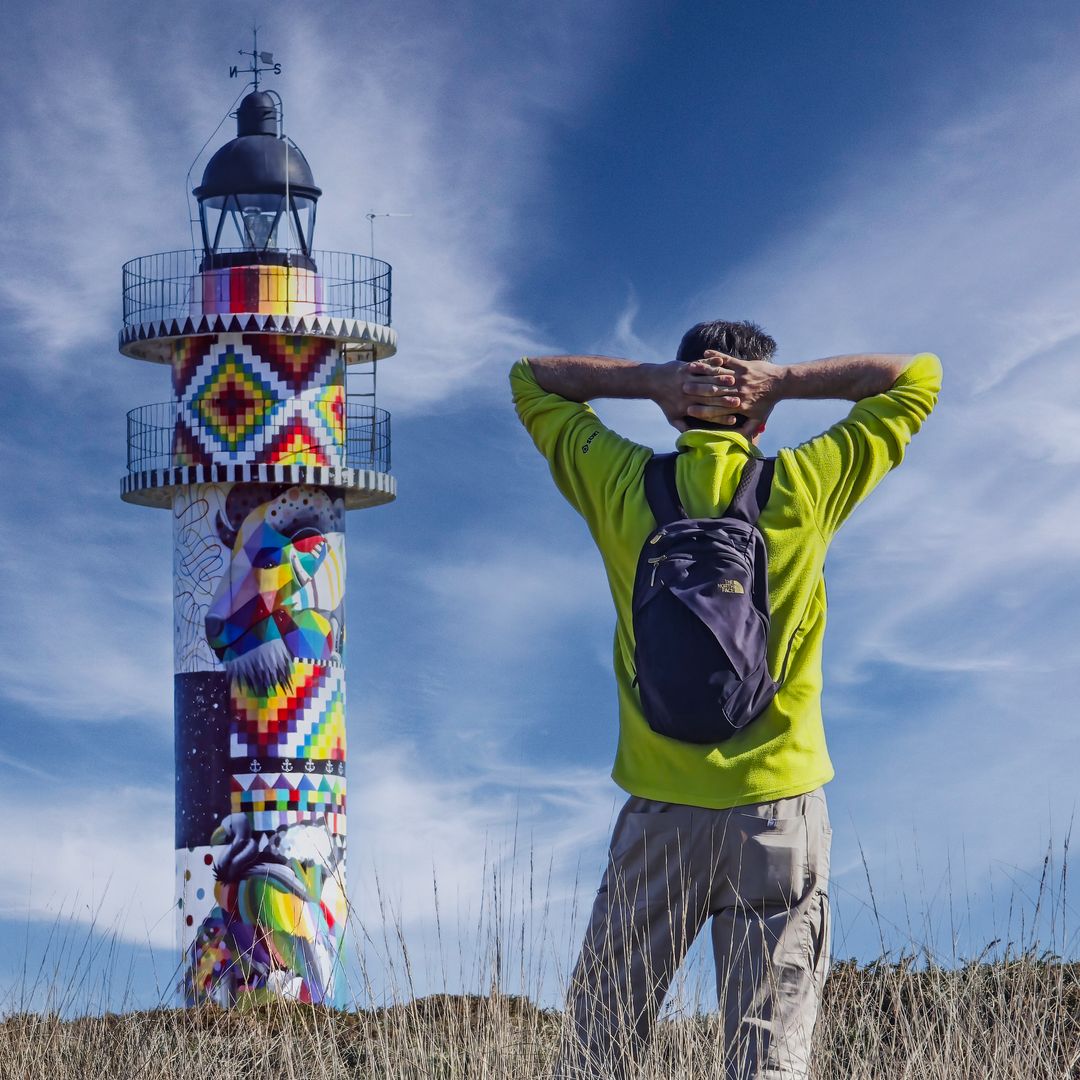 Randoner acercándose al faro pintado por Okuda, Cabo de Ajo, Cantabria 