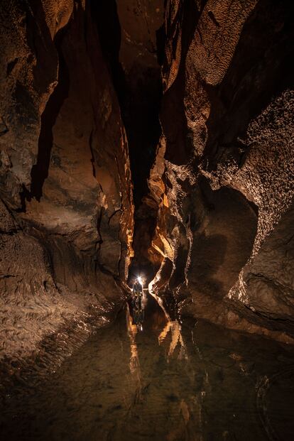 Un espeleólogo en un pasaje dentro de la cueva Coventosa, Cantabrie.