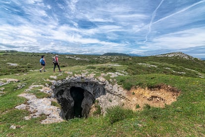 Dos caminantes al lado de la cueva Cúlebre.
