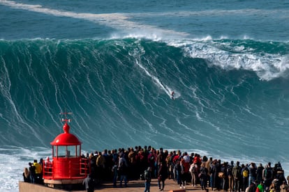Docenas de fanáticos observan al surfista Rodrigo Koxa en la playa de Nazaré (Portugal).