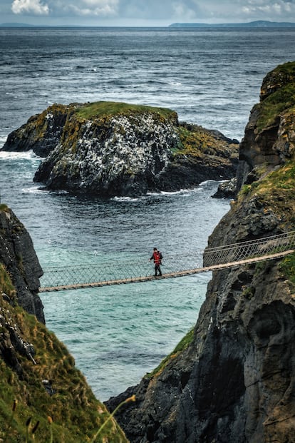 Una persona que cruza el puente Carrick-A-Rollars.