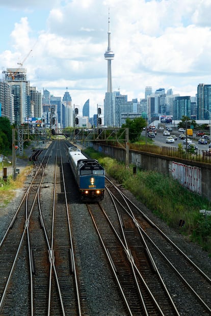 Un tren deja atrás el Downtown de Toronto, con la Torre CN al fondo (Canadá).