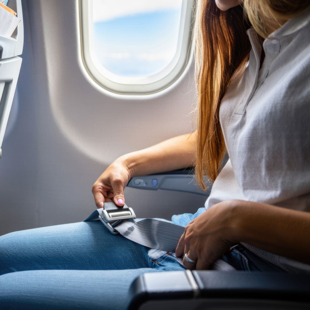 Femme fusionnant sa ceinture de sécurité dans un avion